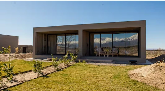 Lodge con ventanales frente a la cordillera